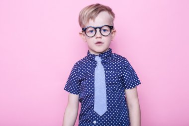 Şık çocuk gömlek ve gözlük kocaman bir gülümseme ile. Okul. Okul öncesi. Moda. Stüdyo portre pembe bir arka plan üzerinde
