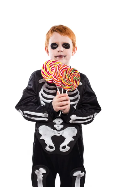 Glücklicher kleiner Junge im Skelett-Kostüm mit bunten Bonbons — Stockfoto