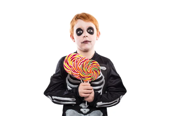 Portret van kleine jongen draagt halloween kostuum en kleurrijke snoepjes te houden — Stockfoto