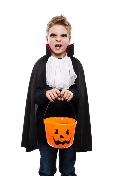 Roztomilý chlapec, oblečený jako upír Halloween a drží dýně koš — Stock fotografie