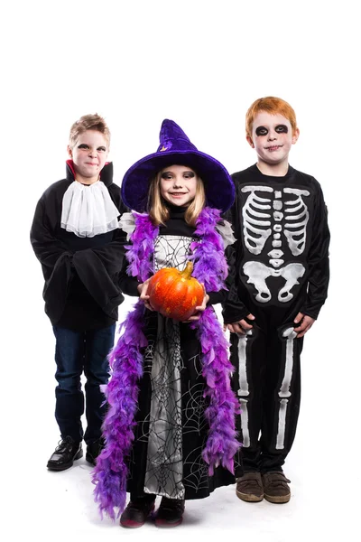 Ein kleines Mädchen und zwei Jungen in den Halloween-Kostümen: Hexe, Skelett, Vampir — Stockfoto