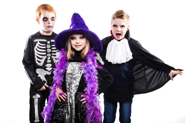Trzy słodkie dziecko ubrany kostiumy Halloween: czarownica, szkielet, wampir — Zdjęcie stockowe