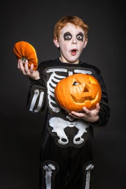 Kızıl saçlı çocuk içinde turuncu kabak tutan Halloween kılık şaşırttı. İskelet