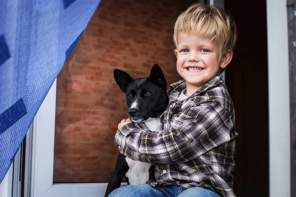 Leende vackra blonda barn och sin hund. Pojke och basenji — Stockfoto