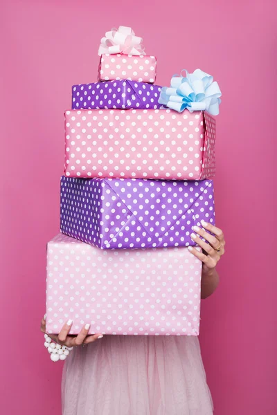 Beautiful woman's hands holding a colorful big and small gift boxes with ribbon. Soft colors. Christmas, birthday, Valentine day Stock Picture