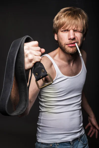 El hombre enojado amenaza con el cinturón. Concepto: Violencia contra las mujeres. Abuso — Foto de Stock