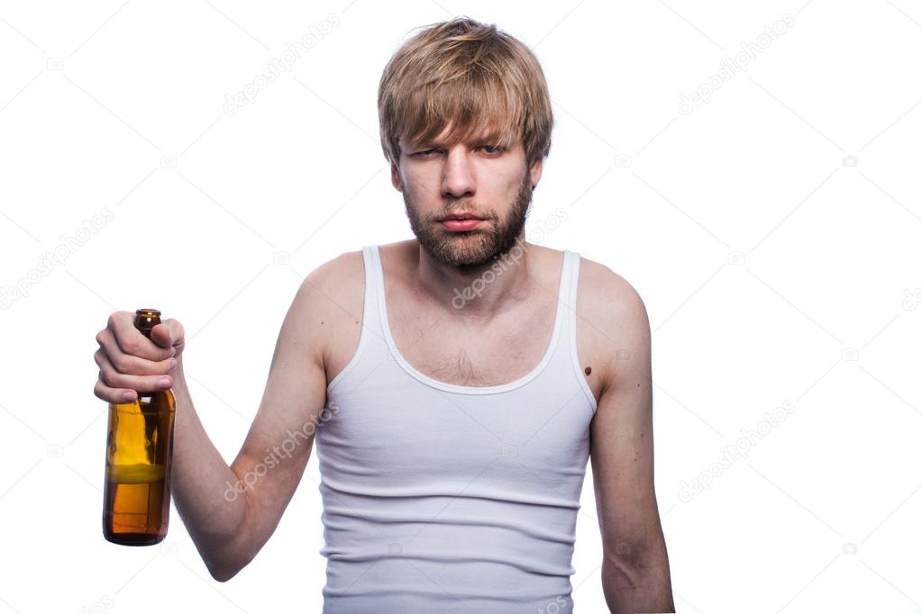 Young man with hangover holding beer bottle. After party Stock Photo by ©bekupe 58678037