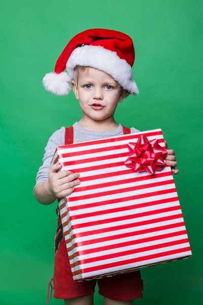 Christmas Elf innehar stor röd presentask med band. Santa Claus helper — Stockfoto