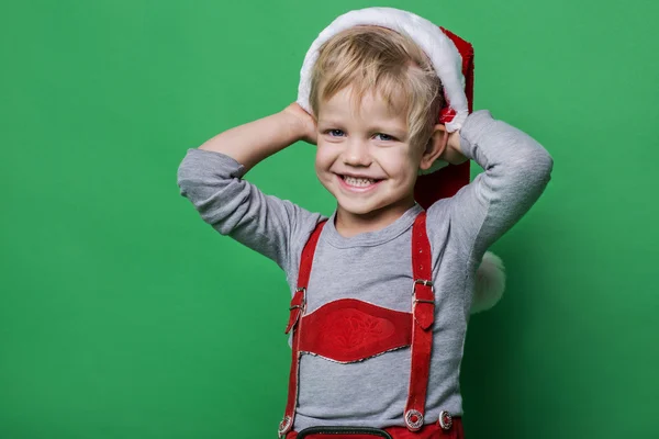 Krásný chlapeček oblečený jako Santa Claus pomocníka s úsměvem. Vánoční koncepce — Stock fotografie