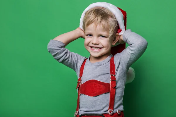 Lindo menino vestido como Papai Noel ajudante sorrindo. Conceito de Natal — Fotografia de Stock