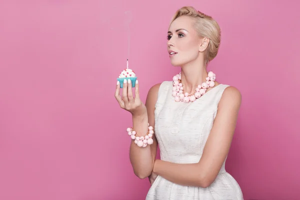 Belle donne con abito in crema che tengono piccola torta con candela colorata. Compleanno, vacanza — Foto Stock