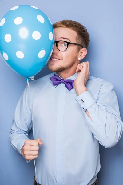 Junger Kerl mit einem bunten Luftballon in der Hand. Party, Geburtstag, Valentinstag — Stockfoto