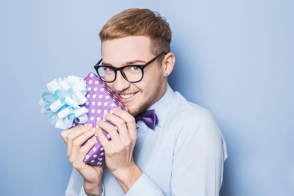Typ, der ein Geschenk in der Hand hält und emotional glücklich ist. Geschenk, Geburtstag, Valentinstag — Stockfoto