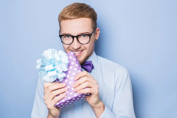 Närbild porträtt av leende man håller färgglada gåva med band. Närvarande, födelsedag, alla hjärtans — Stockfoto