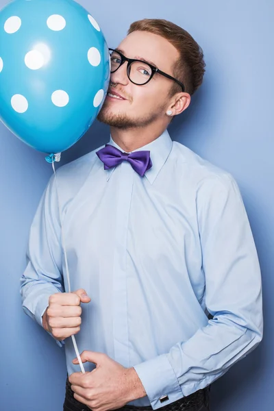 Young guy with a colorful balloon in his hand. Party, birthday, Valentine — Stock Photo, Image