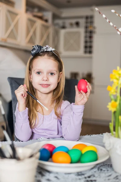 A happy little girl coloring easter eggs — Stock Photo, Image