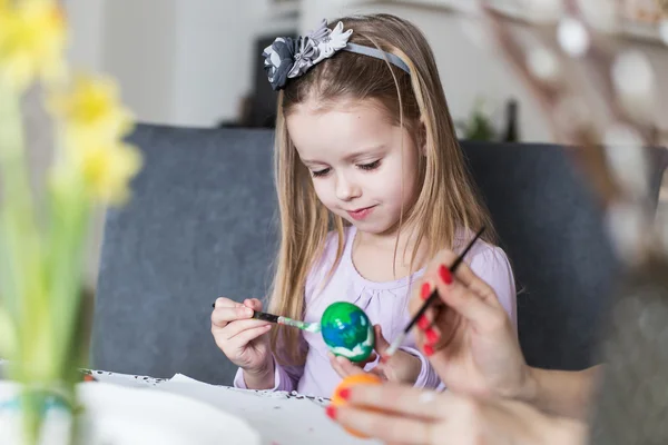 Oster-, Familien-, Urlaubs- und Kinderkonzept - Nahaufnahme des kleinen Mädchens und der Mutter beim Bemalen von Ostereiern — Stockfoto