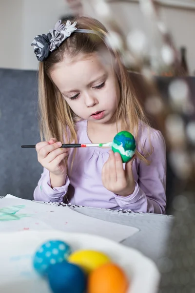 Ein glückliches kleines Kind, das Ostereier färbt — Stockfoto