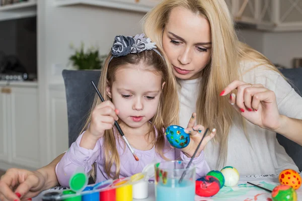 Madre e figlia pittura uova di Pasqua in casa — Foto Stock