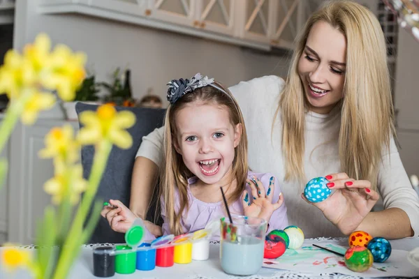 Mère et fille heureuses peignant des œufs de Pâques dans le salon — Photo