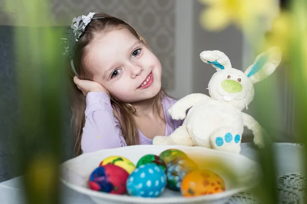 Smiling cute kid with easter eggs and plush bunny. Easter — Stock Photo, Image