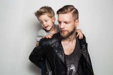 Portrait of young attractive smiling father playing with his little cute son. Fathers day