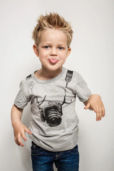 Naughty boy making a grimace and sticking his tongue out — Stock Photo, Image