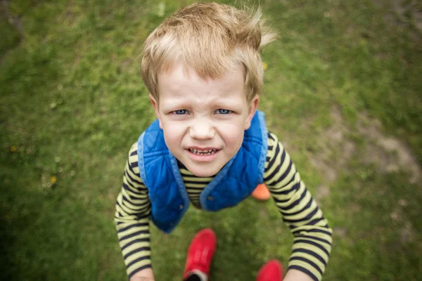 Niegrzeczny chłopiec patrząc w górę. Zewnątrz portret. Z bliska — Zdjęcie stockowe