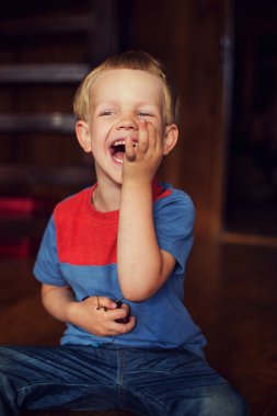 Happy little toddler boy eat berry. Outdoor portrait