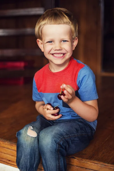 Happy little toddler boy eat berry. Outdoor portrait — Zdjęcie stockowe