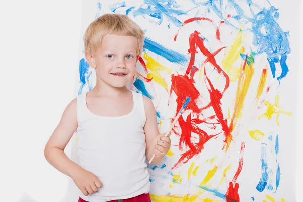 Um menino lindo pinta um quadro. Na escola. Pré-escolar. Educação. Criatividade. Estúdio retrato sobre fundo branco — Fotografia de Stock