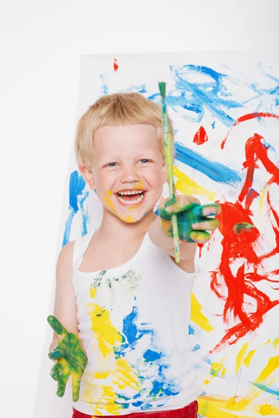 Pequena pintura criança bagunçada com pintura pincel no cavalete. Educação. Criatividade. Na escola. Pré-escolar. Estúdio retrato sobre fundo branco — Fotografia de Stock