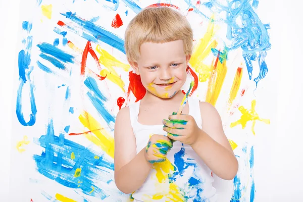 Pequeño niño desordenado pintando con cuadro de pincel en caballete. Educación. Creatividad. En la escuela. Preescolar. Estudio retrato sobre fondo blanco — Foto de Stock