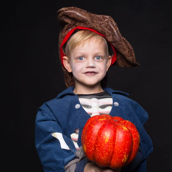 Mały chłopiec w halloween kostium pirat pozowanie z dyni na czarnym tle. Portret Studio — Zdjęcie stockowe