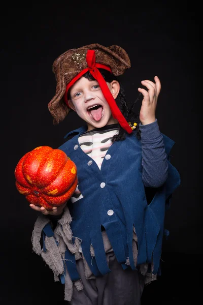 Entzückender kleiner Junge im Piratenkostüm, der zu Halloween Tricks oder Leckereien spielt. Studioporträt über schwarzem Hintergrund — Stockfoto