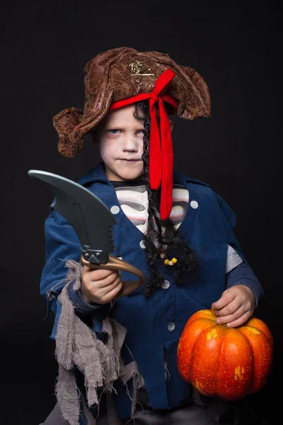 Entzückender kleiner Junge im Piratenkostüm, der zu Halloween Tricks oder Leckereien spielt. Studioporträt über schwarzem Hintergrund — Stockfoto