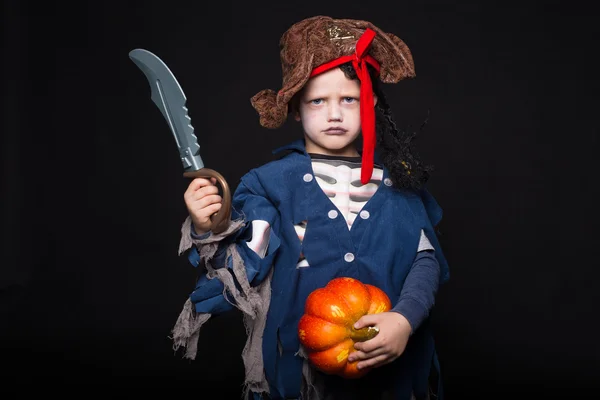 Entzückender kleiner Junge im Piratenkostüm, der zu Halloween Tricks oder Leckereien spielt. Studioporträt über schwarzem Hintergrund — Stockfoto