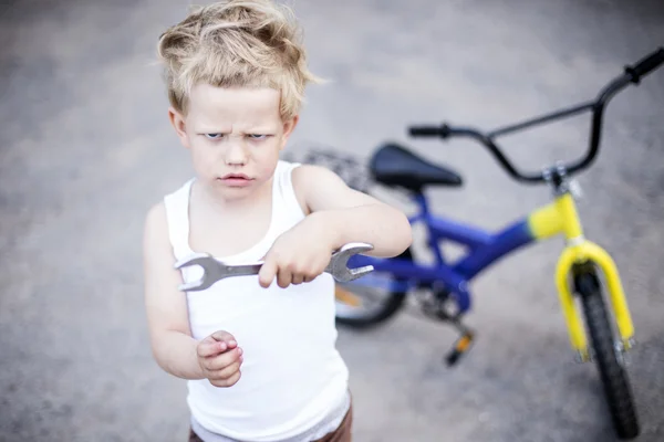 Funny toddler boy repairing his broken bike. Childhood.Cycling — Stock Photo, Image