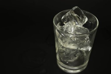 siyah bir zemin üzerine bir bardak buz.