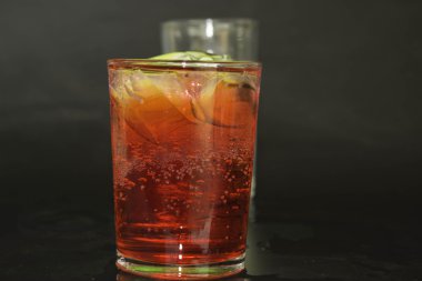 Kırmızı ve yeşil süt ve bir siyah arka plan üzerine bir bardak buz.