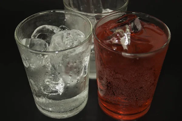 Vatten i ett glas rött på svart bakgrund. — Stockfoto