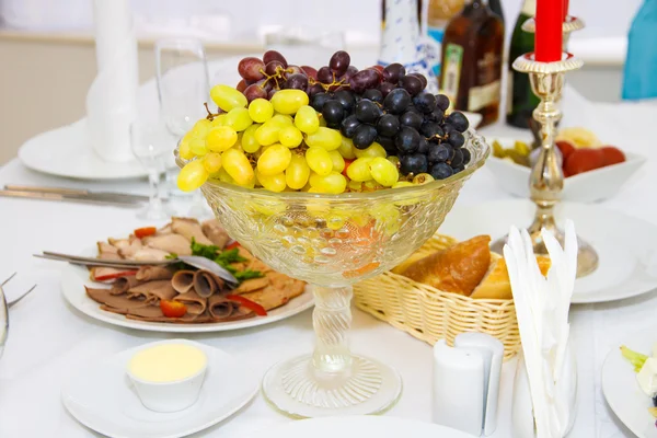Druiven in een vaas op tafel vakantie. — Stockfoto