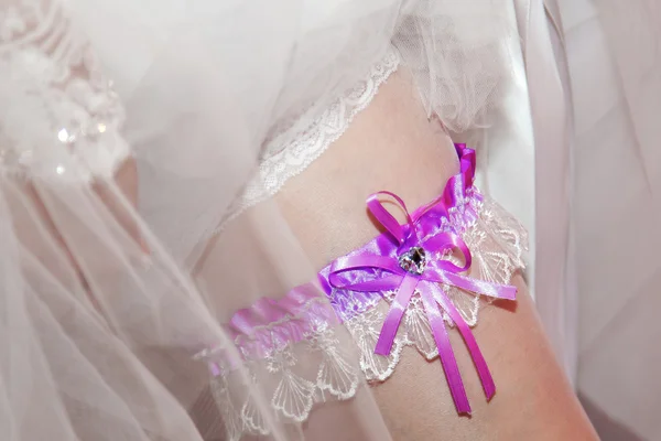 Brides garter on leg.