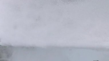 Basınç altında köpüklü güçlü bir jet. Su sıçratan beyaz köpüğün arka planı.