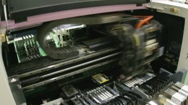 Mikroçiplerin uygulanması için basılı devre kartı üretim robotu. Yazıcı panolarının yazılım çipi ile makine üzerinde hazırlanması.