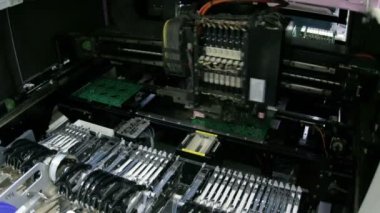 Mikroçiplerin uygulanması için basılı devre kartı üretim robotu. Yazıcı panolarının yazılım çipi ile makine üzerinde hazırlanması.