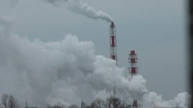 Fabrika borularından su buharı. İnsan üretiminin sera etkisi nedeniyle çevreye ve iklime zarar.