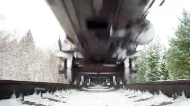 Trenle en altta yarışan kamyonların görüntüsü. Kış ormanlarında yağmur yağar. Kuzey yolunda benzin ve benzin deposu olan çoklu tren..
