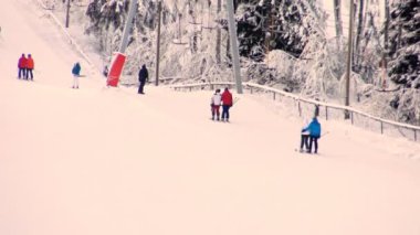 Kayakçılar gün batımında yamaca tırmanıyor..