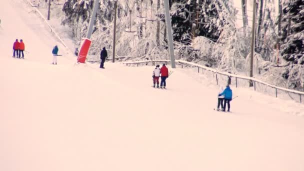 滑雪者在日落时爬上滑雪场的斜坡. — 图库视频影像